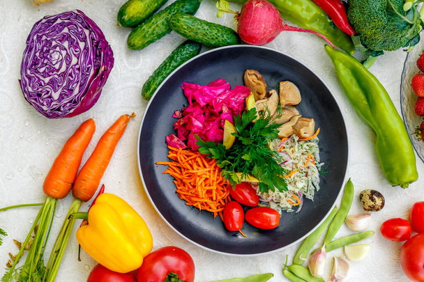 вегетаріанська страва з овочами. Помідори, морква, капуста, гриби та буряк
 - Фото, зображення