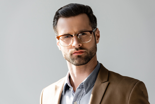 handsome businessman in glasses looking at camera isolated on grey  - Fotografie, Obrázek
