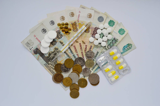 paper notes. currency on a white background close-up. White packaging with pills next to money. The high cost of treatment - Zdjęcie, obraz
