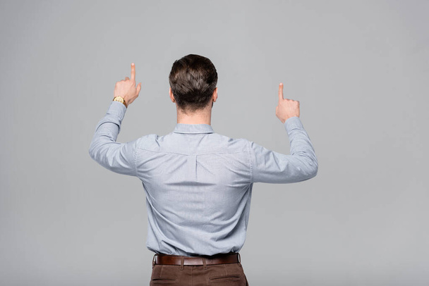 back view of businessman pointing with fingers isolated on grey  - Fotografie, Obrázek