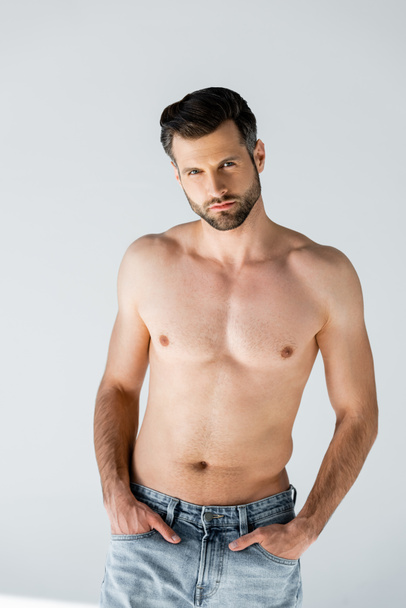 handsome and shirtless man standing with hands in pockets on grey  - Photo, Image