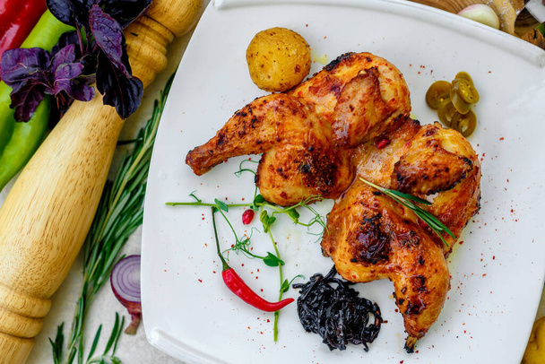 pollo fritto alla griglia con cipolla e peperoncino su un tavolo decorato
 - Foto, immagini