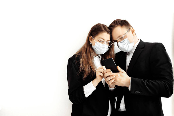 Young business people wearing face masks using smartphone - Photo, Image