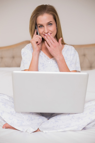 Natural surprised woman using laptop and phoning - Photo, image