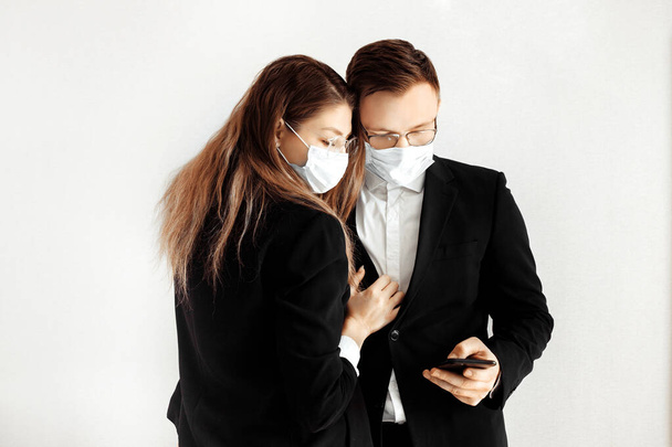 Young business people wearing face masks using smartphone - Foto, immagini