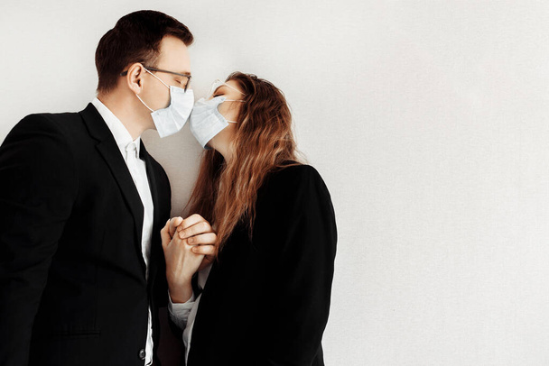 Young business people wearing face masks kissing - Foto, imagen
