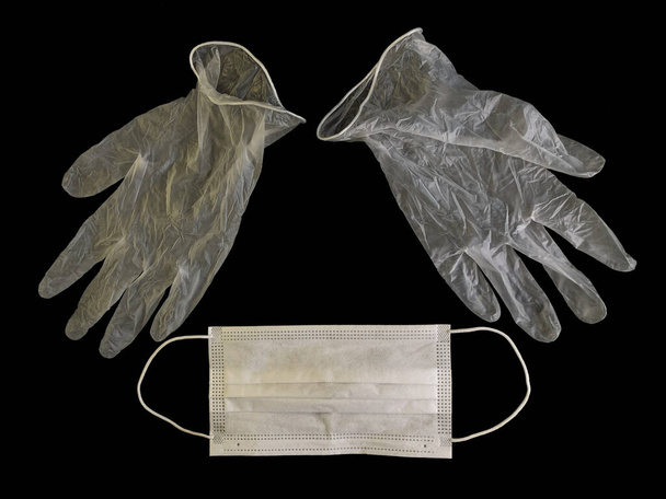 黒い背景に医療用手袋と保護マスク。コロナウイルス感染に対する保護Covid-19.概念:感染症の予防、健康衛生. - 写真・画像