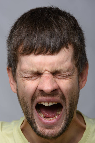 Close-up retrato de um bocejo homem de aparência europeia com boca larga e aberta
 - Foto, Imagem