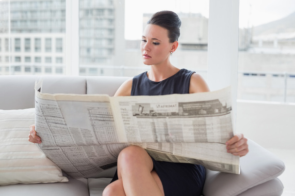 Beautiful businesswoman reading newspaper on sofa - Zdjęcie, obraz