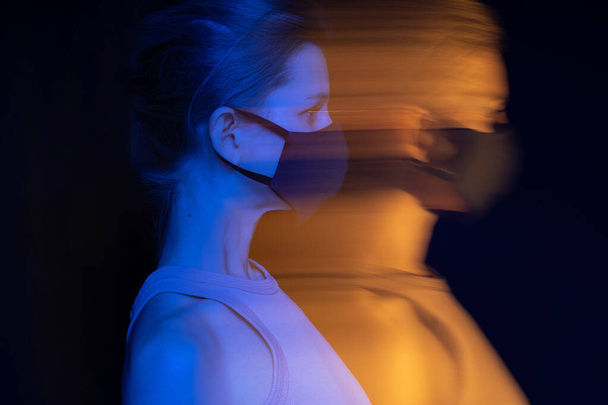 face mask. woman profile looking side. Long exposure creative portraits virus epidemics theme. Black, orange and blue colors. Sad emotions. Personal protection. disaster impact on society. crisis - Fotoğraf, Görsel