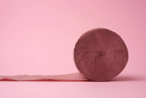 untwisted roll of pink toilet paper on a pink background, close up - Foto, Imagen
