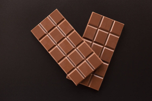Chocolate on a dark background. Two chocolate bars - Фото, изображение