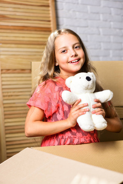 Happy childhood. Small child prepare toys for relocation. Kid girl relocating boxes background. Relocating concept. Delivery service. Relocating family stressful for kids. Box package and storage - Фото, зображення