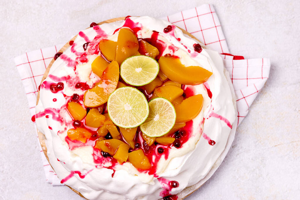Pavlova Meringue Cake Decorated With Peach Berry Jam and Lime Tasty Homemade Summer Dessert Horizontal Top View - Foto, immagini