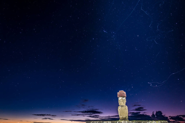 Ahu Ko Te Riku moai com olhos em Rapa Nui à noite com trilhas de insetos
 - Foto, Imagem