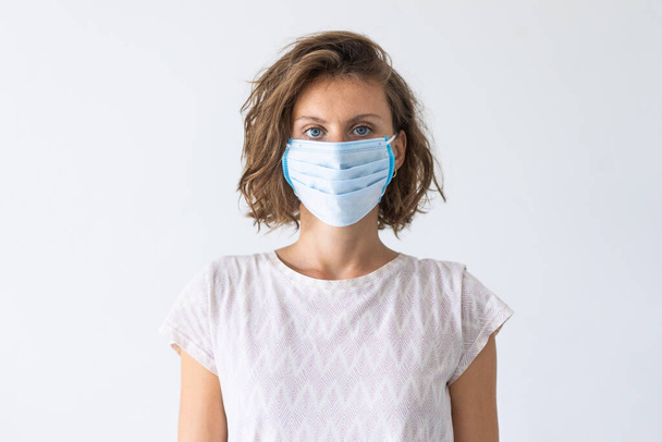 顔の医療マスクを着た女性。インフルエンザの流行、ほこりアレルギー、ウイルスからの保護。Covid-19, coronavirusパンデミック - 写真・画像