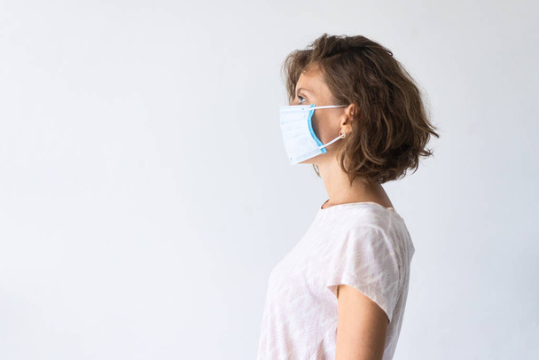 Yüz maskesi takan bir kadın. Grip salgını, toz alerjisi, virüse karşı koruma. Covid-19, koronavirüs salgını - Fotoğraf, Görsel