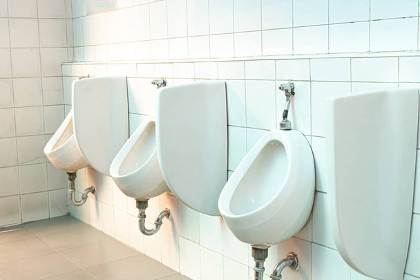 Desenho de urinóis brancos dos homens, close-up linha de urinóis ao ar livre homens banheiro público, conceito urinário
. - Foto, Imagem