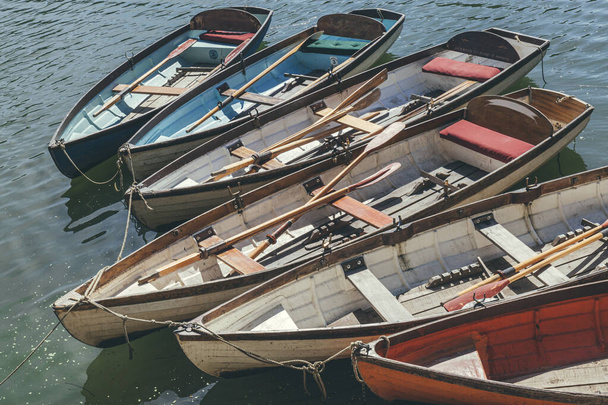 Wooden rowboats with oars inside, moored at the Thames riverside - Photo, Image