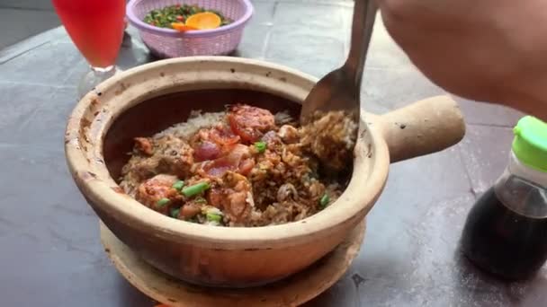 Claypot Chicken Rice Chinesische Wurst dampft heiß wird von asiatischen männlichen Chinatown Kuala Lumpur, Malaysia gerührt. Gesichtspunkt Schuss Abendessen. Üblicherweise über Holzkohlefeuer gekocht. - Filmmaterial, Video