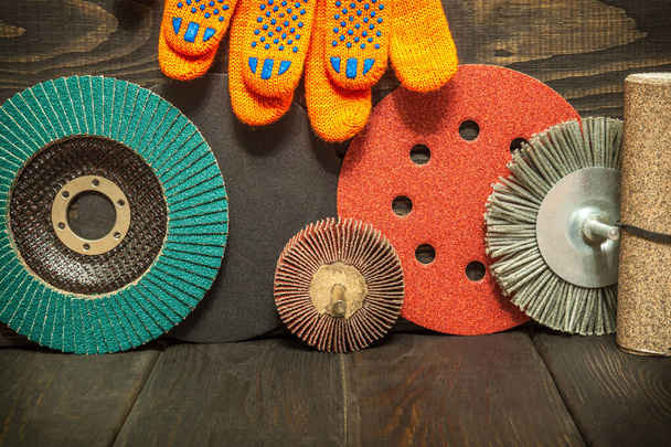 Великий набір абразивних інструментів і помаранчевих робочих рукавичок на чорних старовинних дерев'яних дошках майстер використовується для шліфування предметів
 - Фото, зображення