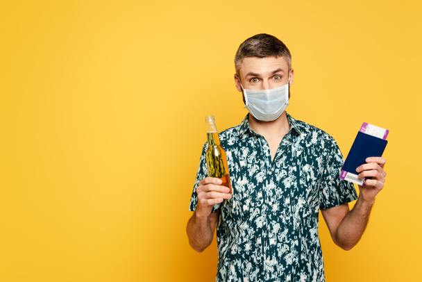 guy in medical mask with beer and passport on yellow - 写真・画像