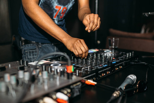 Close-up van DJ 's hand die muziek speelt aan draaitafel op een party festival  - Foto, afbeelding
