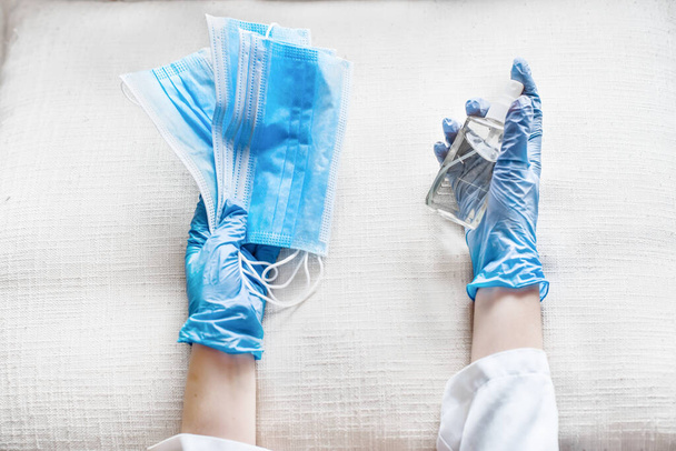 A hands in gloves taking for coronavirus prevention medical masks and sanitizer spray for hand hygiene corona virus protection.Concept of healthy life and prevention corona virus. - Fotografie, Obrázek