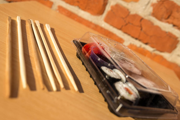 Lieferung nach Hause Sushi. Sushi mit dir. Sushi in einer Plastikbox. - Foto, Bild