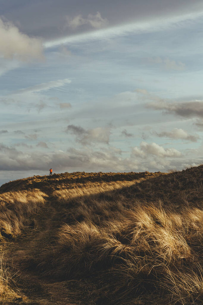 Неідентифікована людина йде уздовж узбережжя Північного моря в місті Брена. Брена (англ. Brora) - село на сході Сазерленда, в гірській місцевості Шотландії.. - Фото, зображення