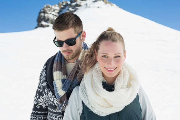 Couple in warm clothing in front of snowed hill - Φωτογραφία, εικόνα