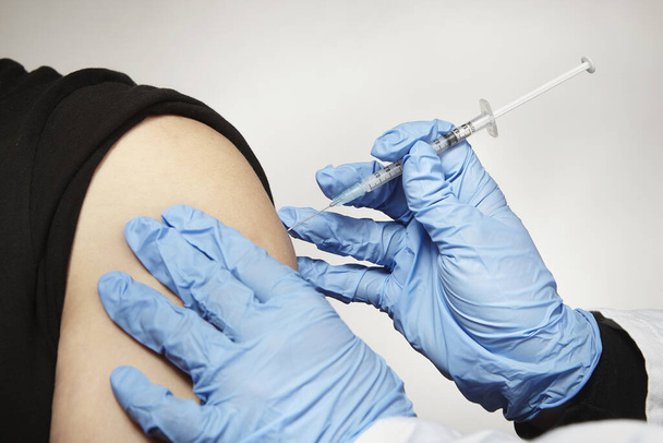 Szczegóły szczepienia nieznanego człowieka szczepionką przeciw chorobie Kowid-19 - Zdjęcie, obraz