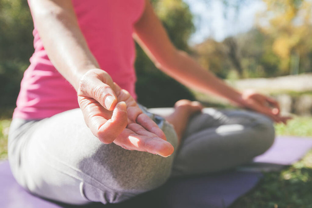 Kobieta medytująca i ćwicząca jogę w parku w piękny słoneczny jesienny dzień - Zdjęcie, obraz