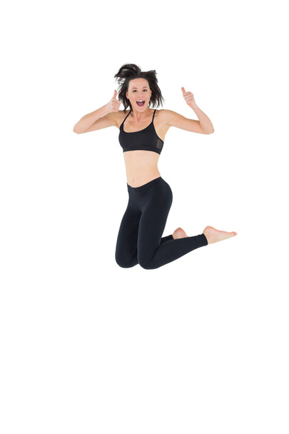 Sporty active young woman gesturing thumbs up - Фото, изображение