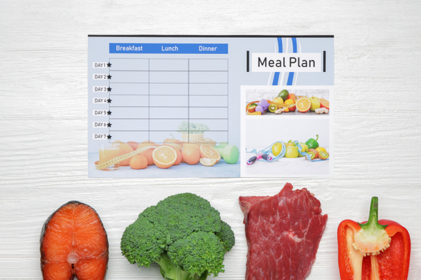 Productos saludables y plan de comidas sobre fondo de madera blanca
 - Foto, imagen