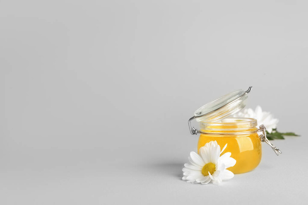 Jar of sweet honey on light background - Фото, зображення