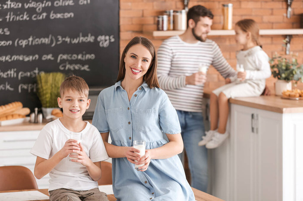 母親とともに彼女の小さな息子飲料牛乳でキッチン - 写真・画像
