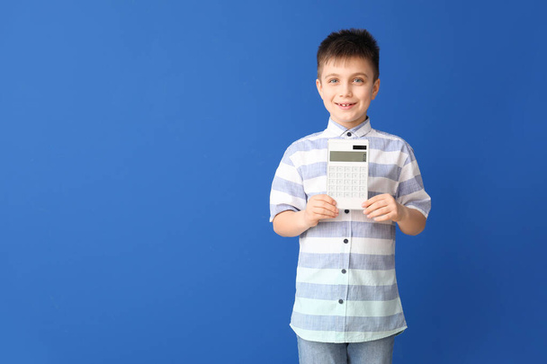 Kleiner Junge mit Taschenrechner auf farbigem Hintergrund - Foto, Bild