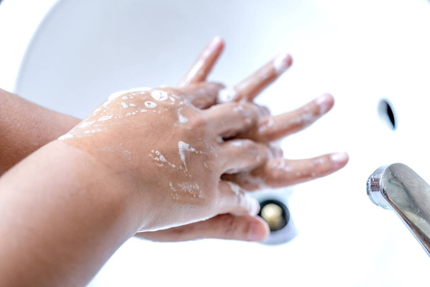 Woman's hands wash their hands with soap, cleanse the hands in the tub with soap, personal hygiene. - Foto, afbeelding