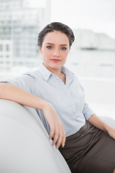 Serious well dressed young woman sitting on sofa - Foto, Imagem