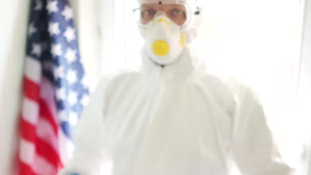 Close up portrait of a man in a protective suit holding a sign saying stay at home. Covid19 coronavirus epidemic in the USA. Quarantine and self-isolation - Footage, Video
