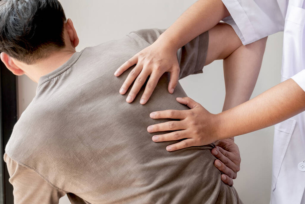 Le fisioterapiste forniscono assistenza fisica ai pazienti di sesso maschile con lesioni alla schiena massaggi per il rilassamento e il recupero muscolare nel centro di riabilitazione. Concetti di fisioterapia
. - Foto, immagini