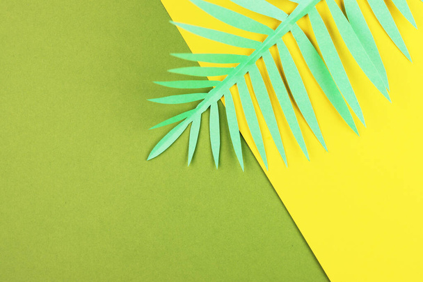 various tropical leaves on a yellow and green background, top view. exotic background with paper green leaves - Zdjęcie, obraz