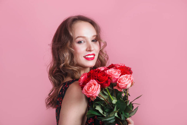 Portrait of a very beautiful sensual and sexy girl with flowers on pink studio background - Zdjęcie, obraz