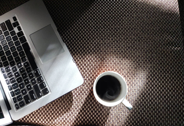 Ordenador portátil y una taza de café para el trabajo desde casa en el momento del bloqueo durante la pandemia del virus de la corona de 2020
 - Foto, Imagen