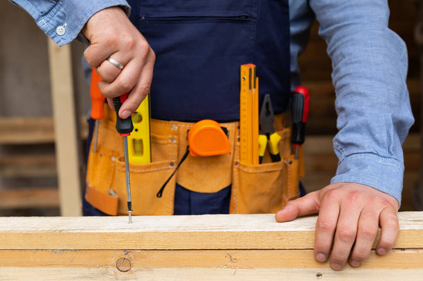 Close up picture of carpenters hands measuring plank - DIY renovation at home - Foto, Imagen