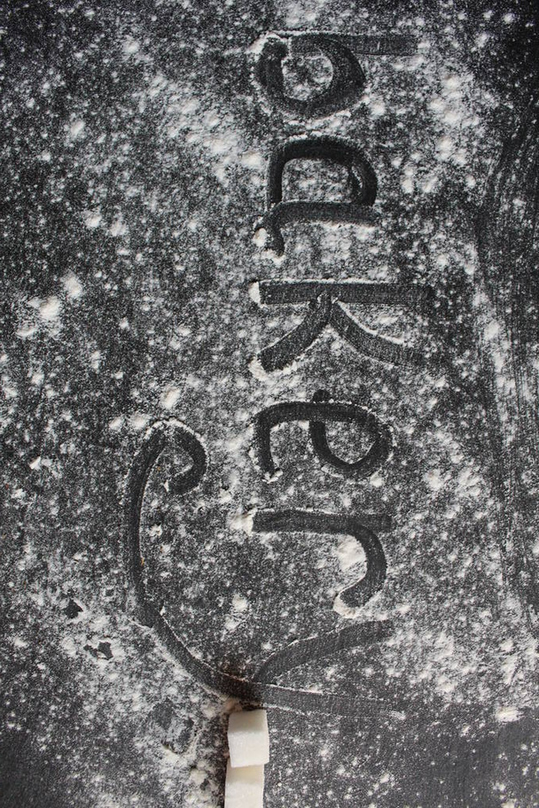 a pékség szó sötét háttérre van írva egy szürke kő lisztes vagy porított cukorkőre, szöveges vagy fotós hellyel - Fotó, kép