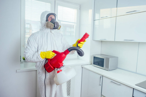 white worker spraying pesticide on induction hob - Foto, Imagem