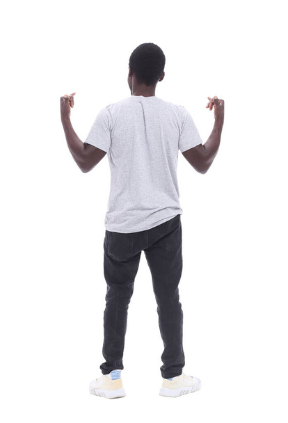 rear view. young man standing in front of white wall - Фото, изображение