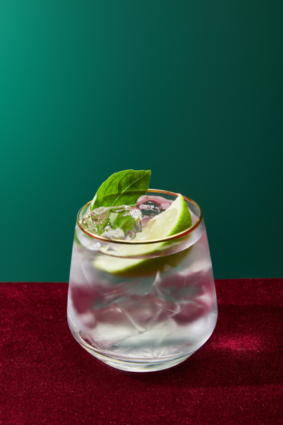 Close up view of old fashioned glass with golden rim with mojito isolated on green  - Fotó, kép